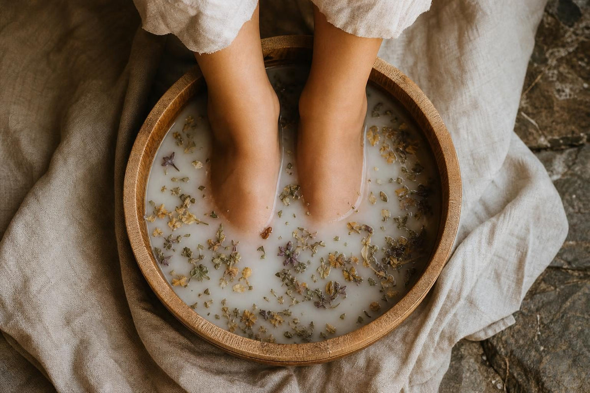 Pieds nus plongés dans une bassine en bois remplie d'eau laiteuse